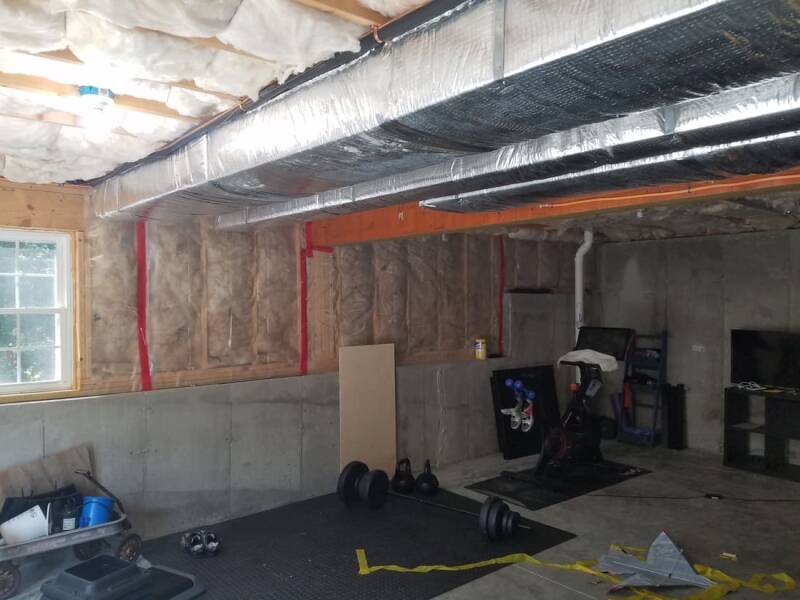 Basement remodel during construction with tools, materials, and unfinished walls visible.