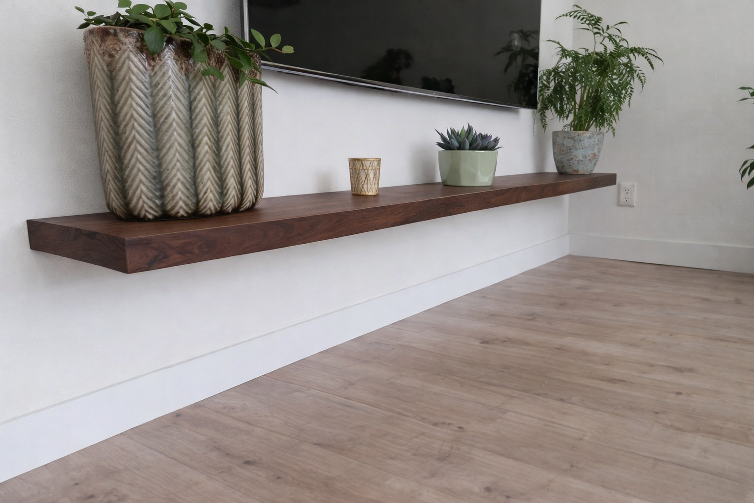 Zwevende wandplank van massief walnoothout onder een tv, blind gemonteerd in de woonkamer.