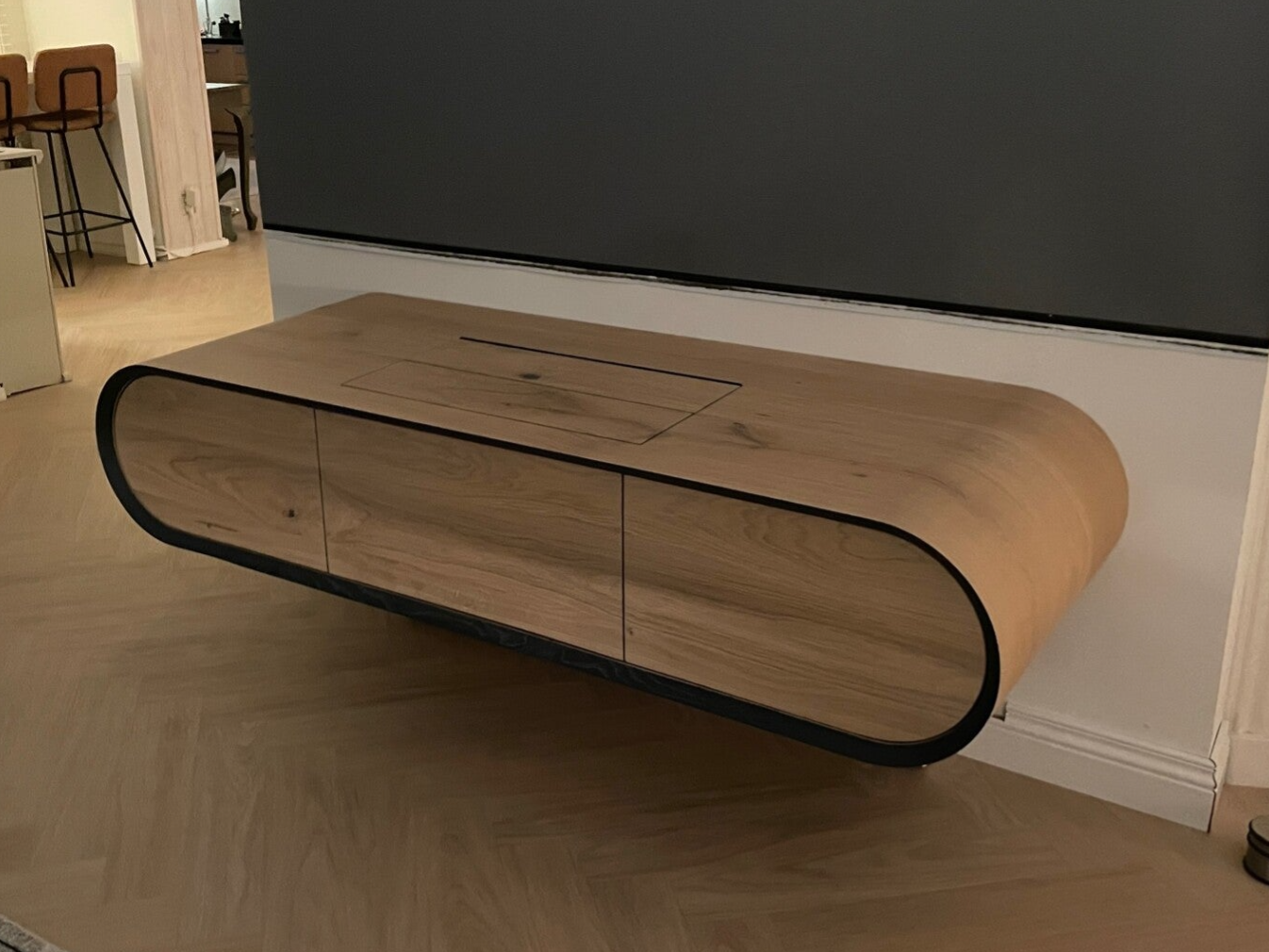 Gebogen TV-meubel op maat van massief hout met rustige, organische vorm