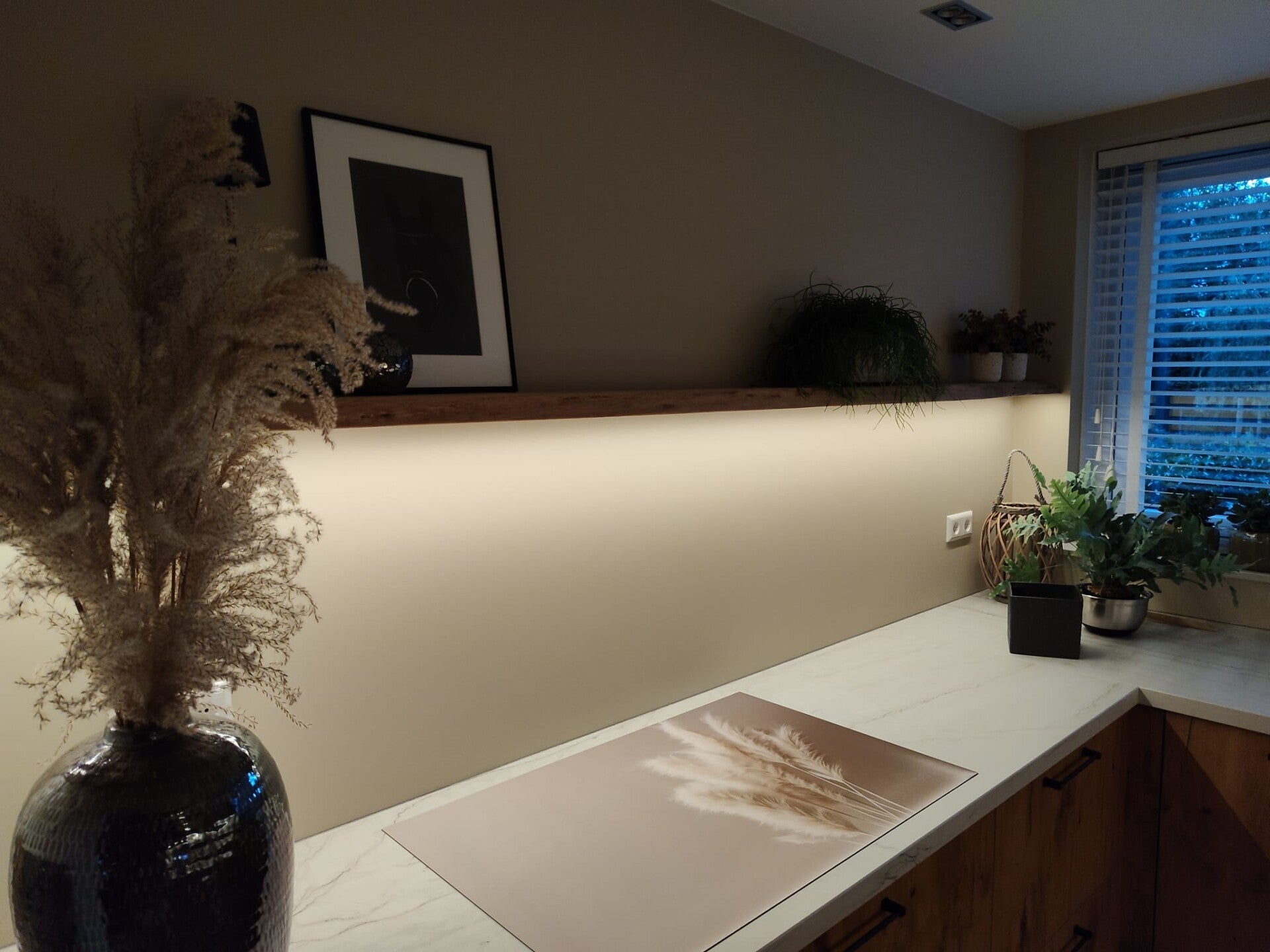 Massief eiken wandplank met geïntegreerde warmwitte LED-verlichting voor sfeervolle verlichting in de keuken.