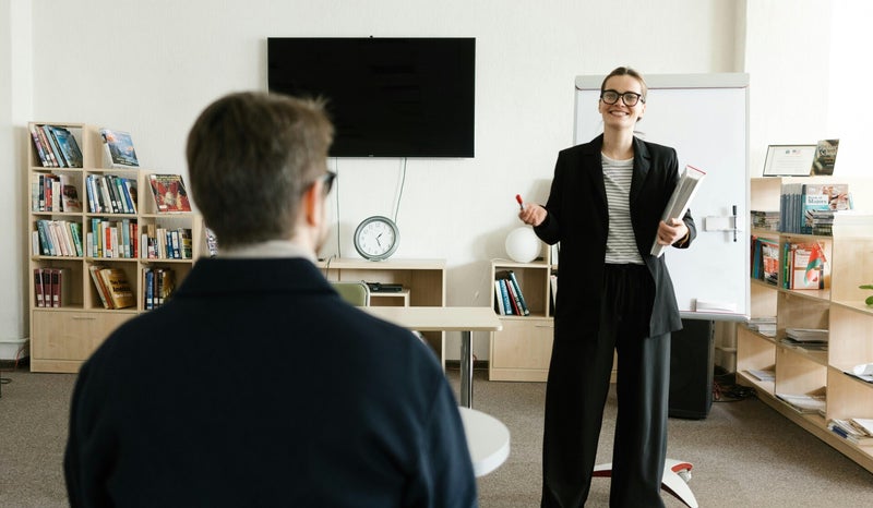 Business woman smiling and practicing a job interview in front of an advisor