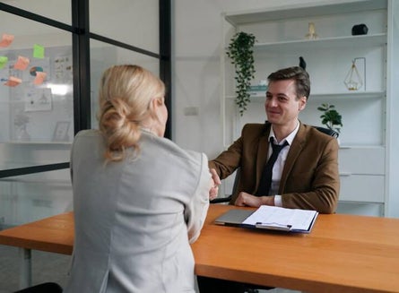 Mujer profesional practicando una presentación frente a un compañero de trabajo
