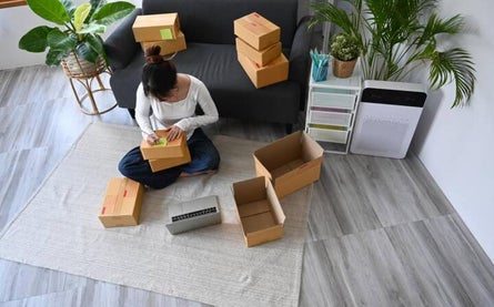 Woman sitting on the floor and tagging boxes before moving apartments