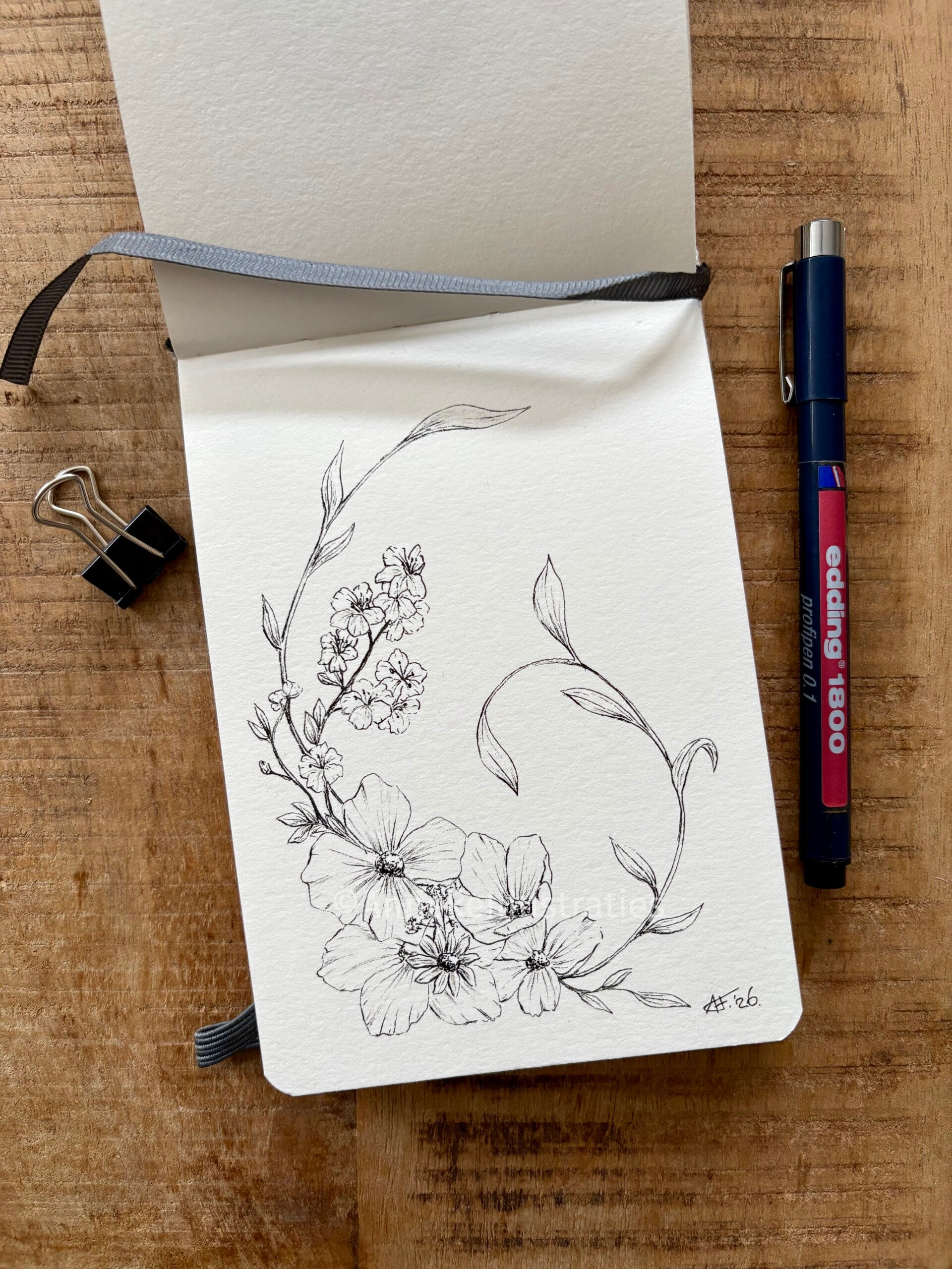 Bladzijde in schetsboek met een zwarte pentekening van bloemen met sierlijke takken 