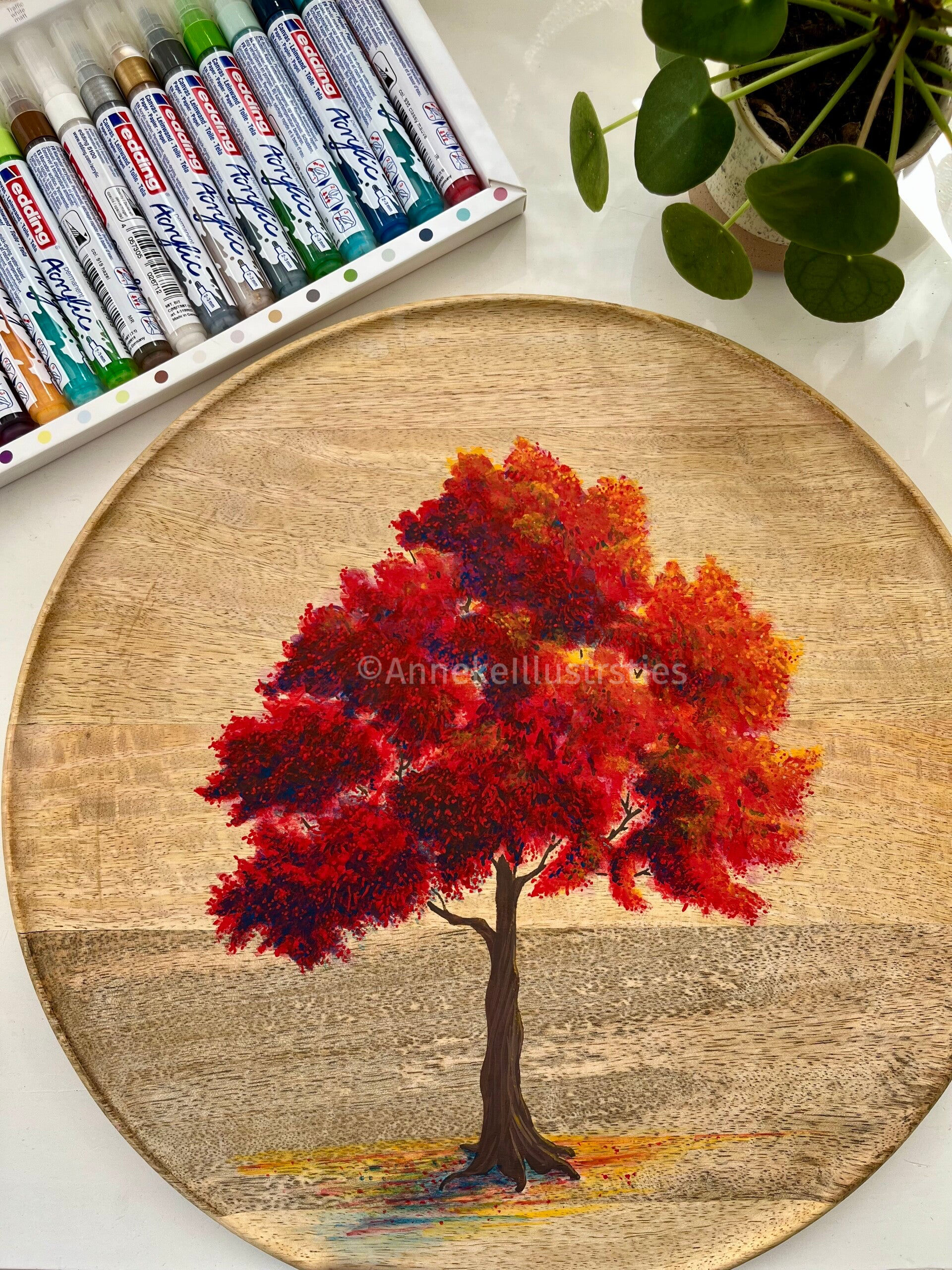 Houten rond bord met een boom geschilders met acrylmarkers.