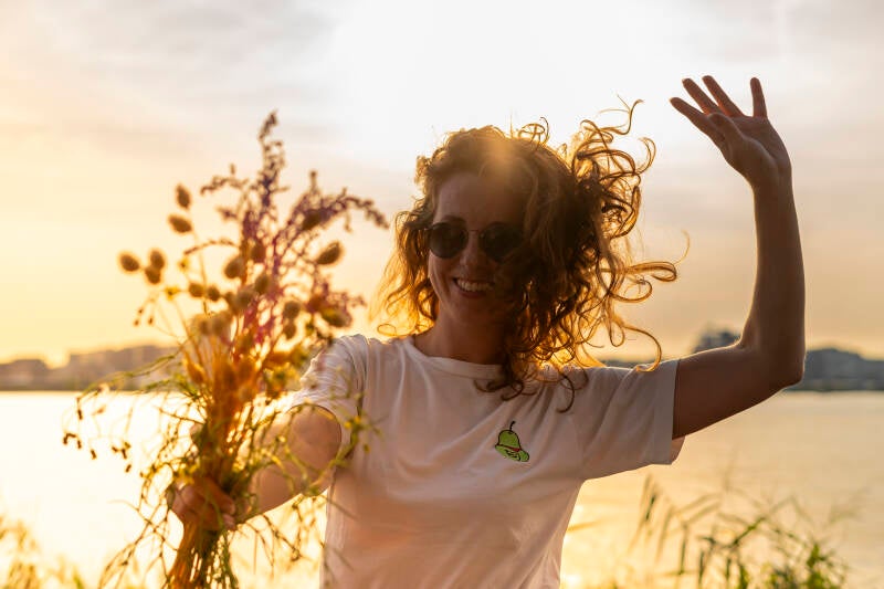 vrouw met een bos bloemen in de ondergaande zon