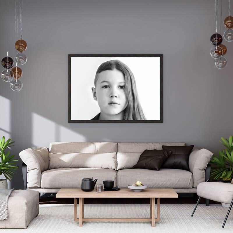 interieurfoto met een bank en een portret aan de muur met een foto van broer en zus