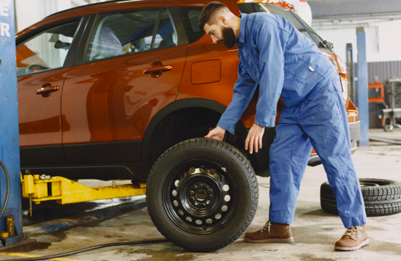 Un mécanicien qui va remplacer le pneu.