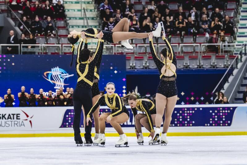 ASV Synchro9 komanda melnos un zelta tērpos uz ledus Zalcburgā
