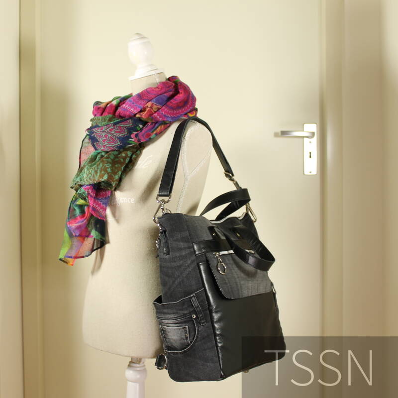 De tas als schoudertas van zwarte spijkerbroek en oud leren bankstel op paspop