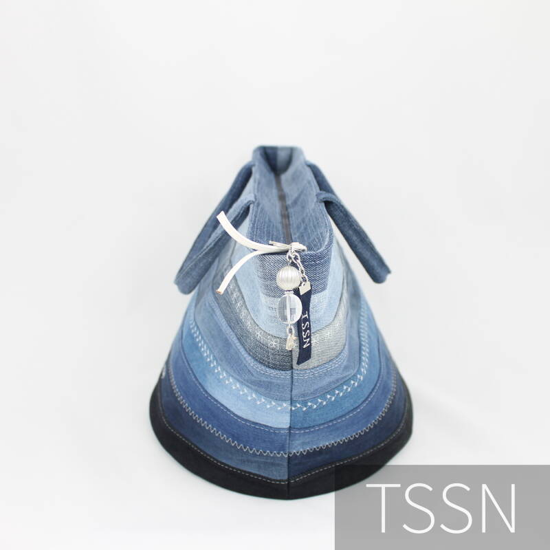 Zijkant bucketbag model Esther van meerdere verschillend gekleurde spijkerbroeken.