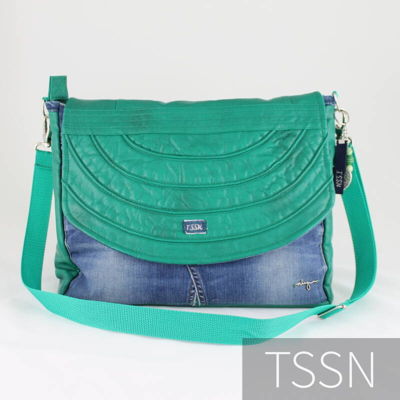 Voorkant messenger-bag model Heidy van spijkerbroek en groen leer jasje.