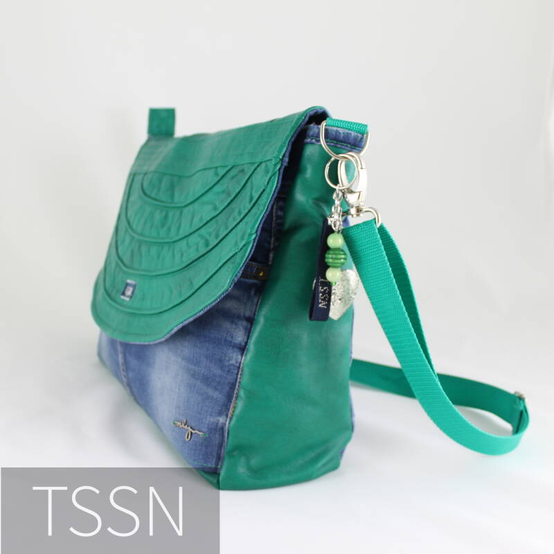 Zijkant messengerbag model Heidy gemaakt van een spijkerbroek en groen leren jasje