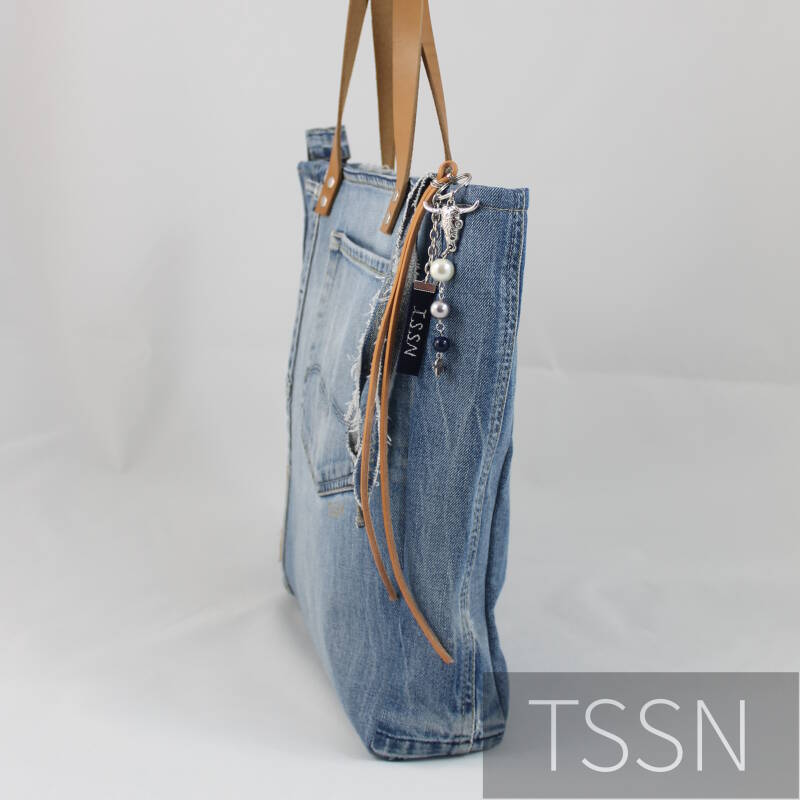 Zijkant stoere shopper model Cindy 1 gemaakt van lichtblauwe spijkerbroek met leren hengsels