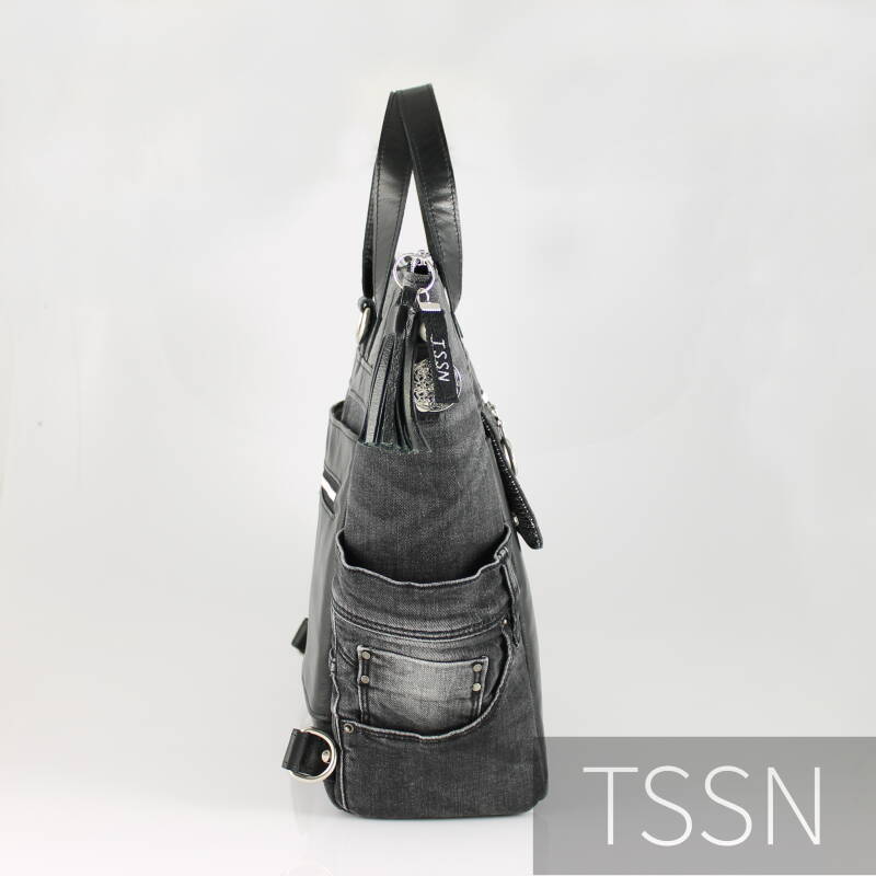 Zijkant tas van zwarte spijkerbroek en oud leren bankstel