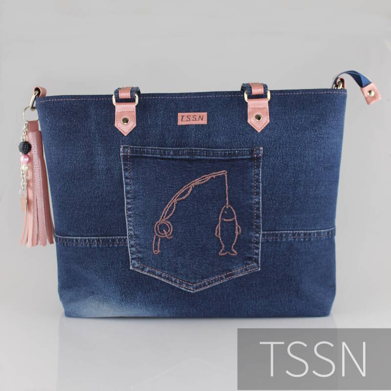 Denim herinneringstas met hengel en vis op de kontzak geborduurd.