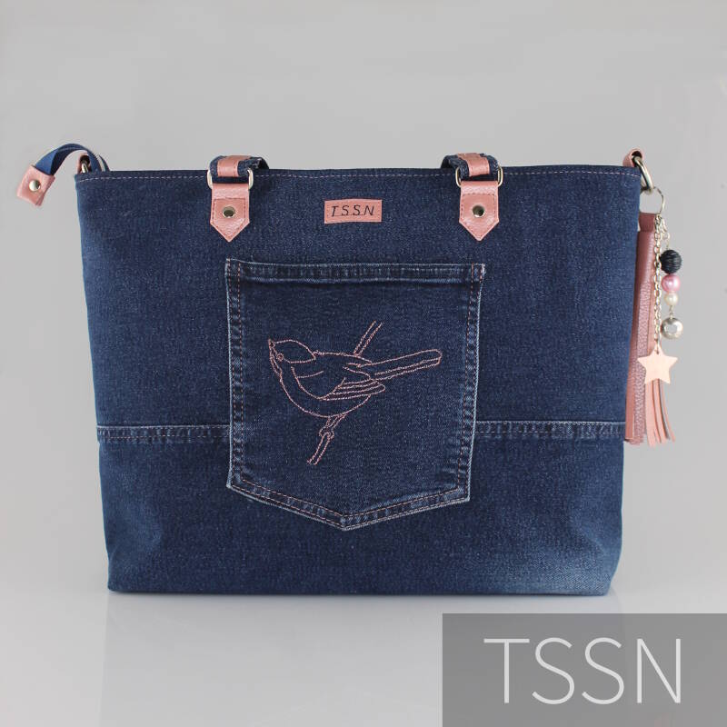 Denim herinneringstas met geborduurd vogeltje op de kontzak.