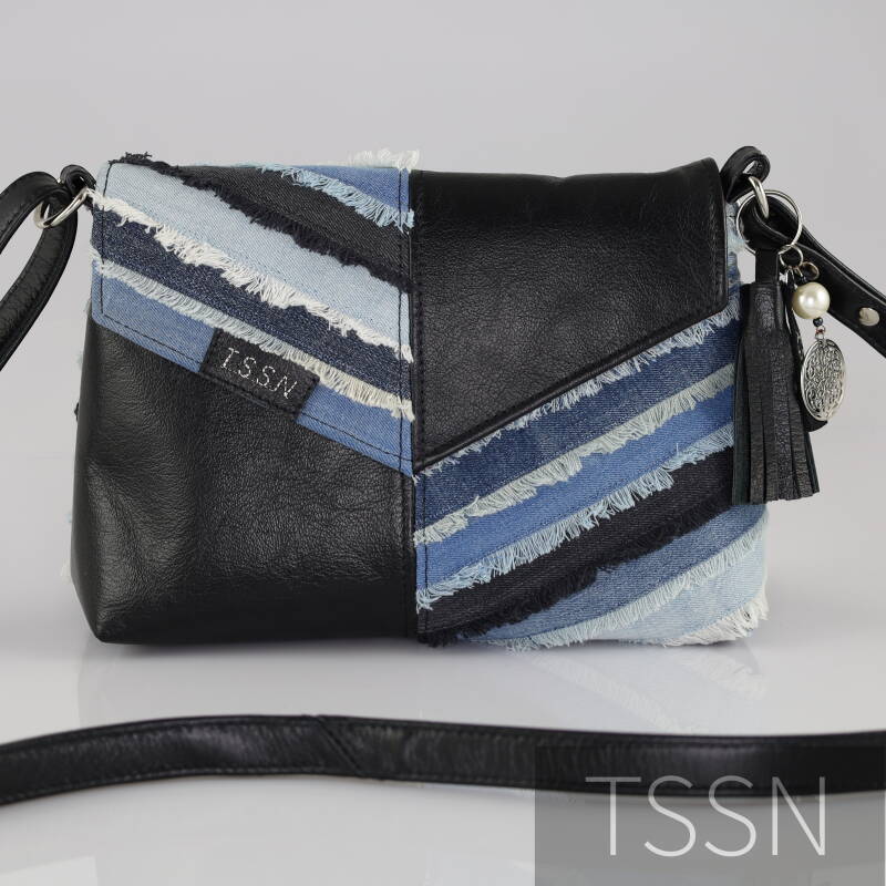 Voorkant tas model Harley van zwart leer van oud bankstel en verschillende kleuren spijkerbroeken