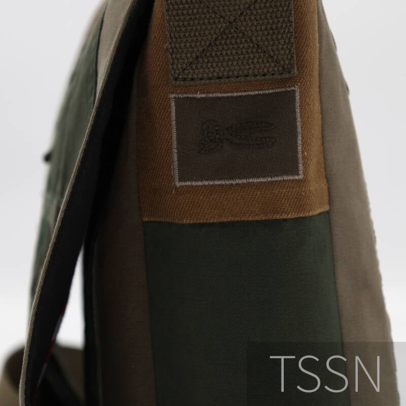 De geborduurde schaar van het merk Denham op de zijkant van de tas.