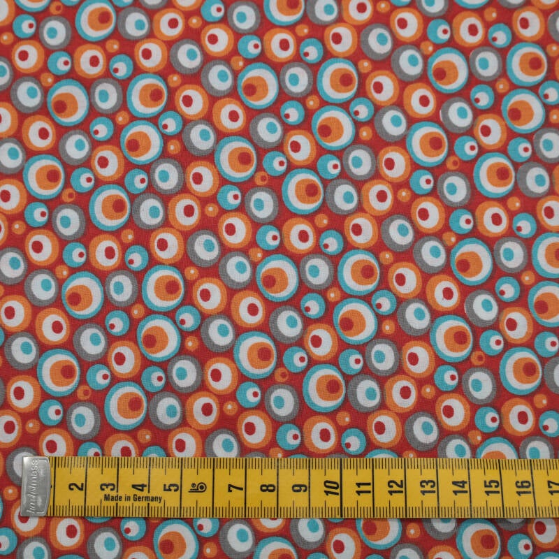 roodoranje ondergrond met balletjes in wit, oranje, rood en turqoise