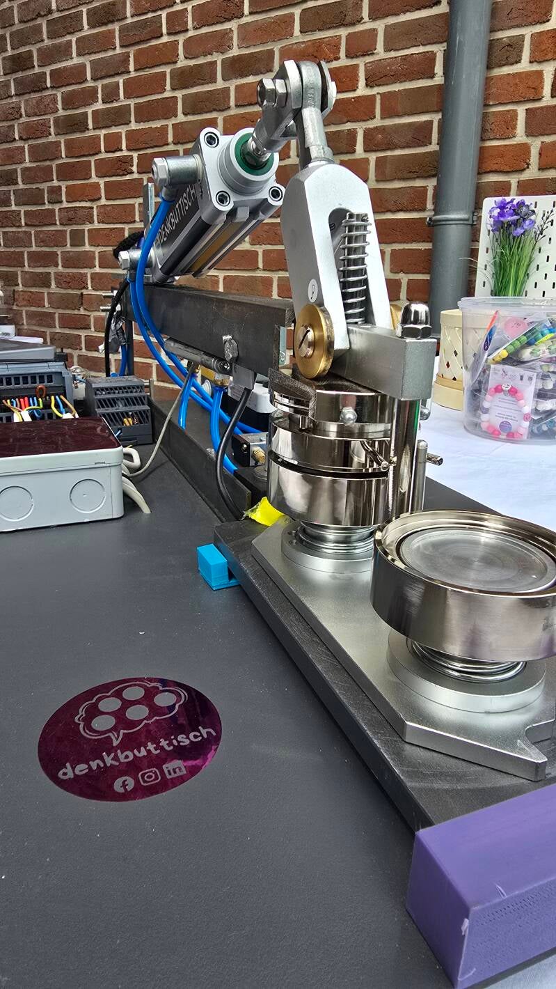 Selbst entwickelte Buttonmaschine von denkbuttisch® auf einem vorbereiteten Workshop-Tisch