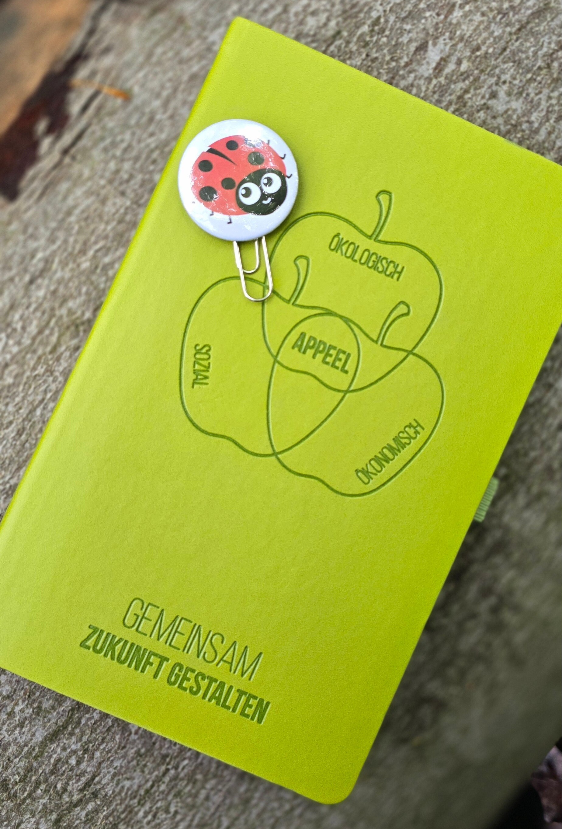 Büroklammer mit Button als Dekoration für ein Notizbuch