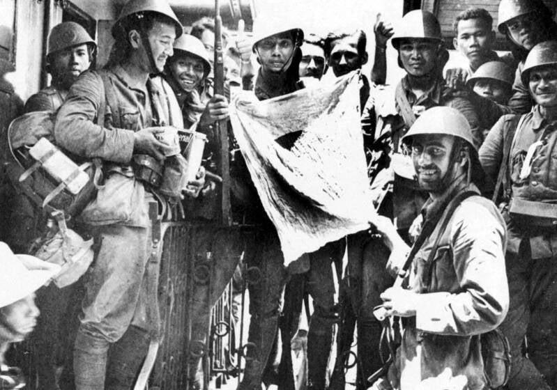 Xe bataljon met een veroverde Japanse vlag na de slag om Palembang.