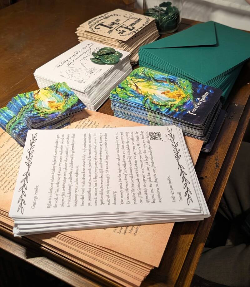 A wooden writing desk covered with stacks of writing papers, cards and illustrations of Tales of The Ever-Awt. Vintage and handmade snail mail post