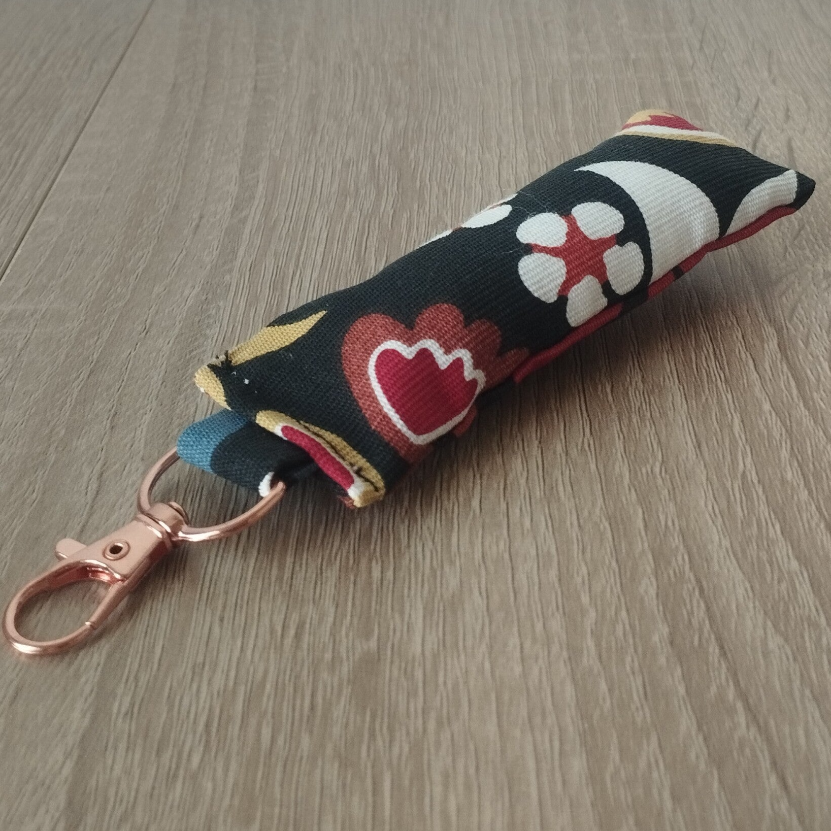 Porte-clés coussin noir cerises boucle dorée rose