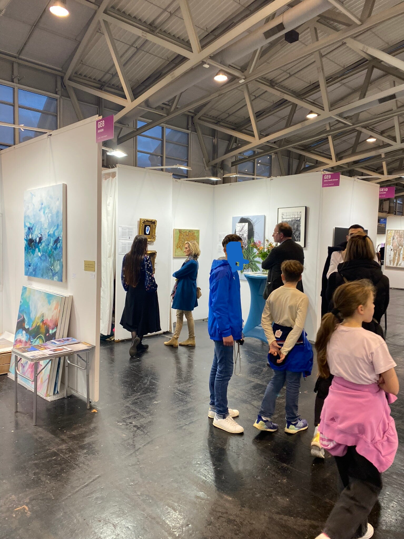 Visitors to the Discovery Art Fair in Frankfurt talking with Artist Nicole Sciarone. Children visit with their parents. Connoisseurs look to expand their collections. Artists come for inspiration. Regular people coming to have a day outing, maybe falling 