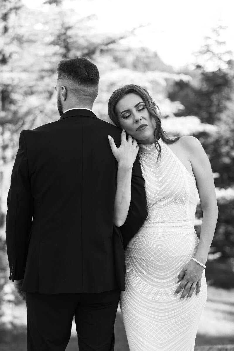Fotografía artística de boda en blanco y negro en Madrid, pareja mirándose con emoción ante un mural religioso – por Chiriac Bogdan.