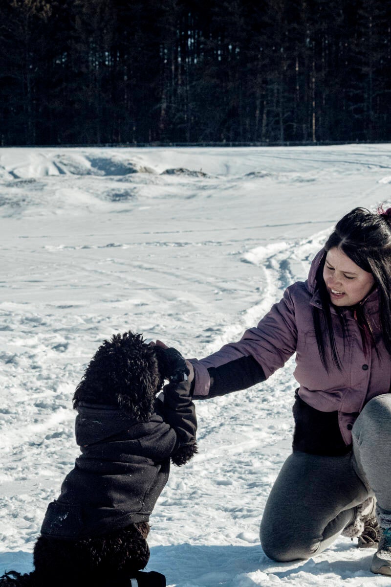 entraineure qui fait faire le beau a un chien