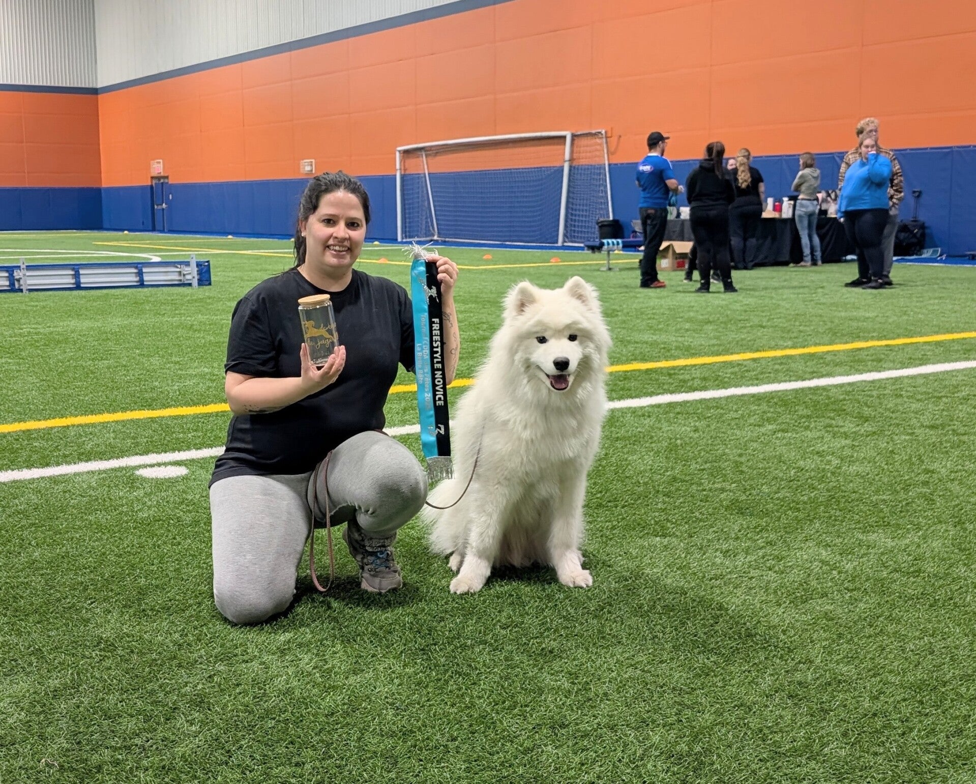 samoyede et son entraineure qui vienne de gagner la 3ieme place en freestyle, poser avec leur ruban bleu et noir a levis