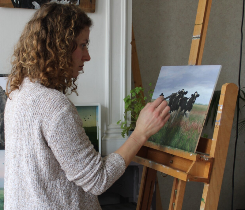 Marieke Poppe schildert een schilderij met zwartbonte Holstein koeien