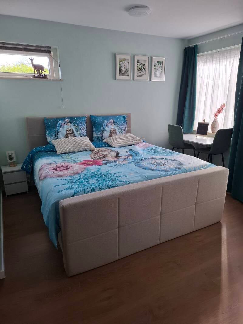 slaapkamer met groot bed, eethoekje en openslaand raam