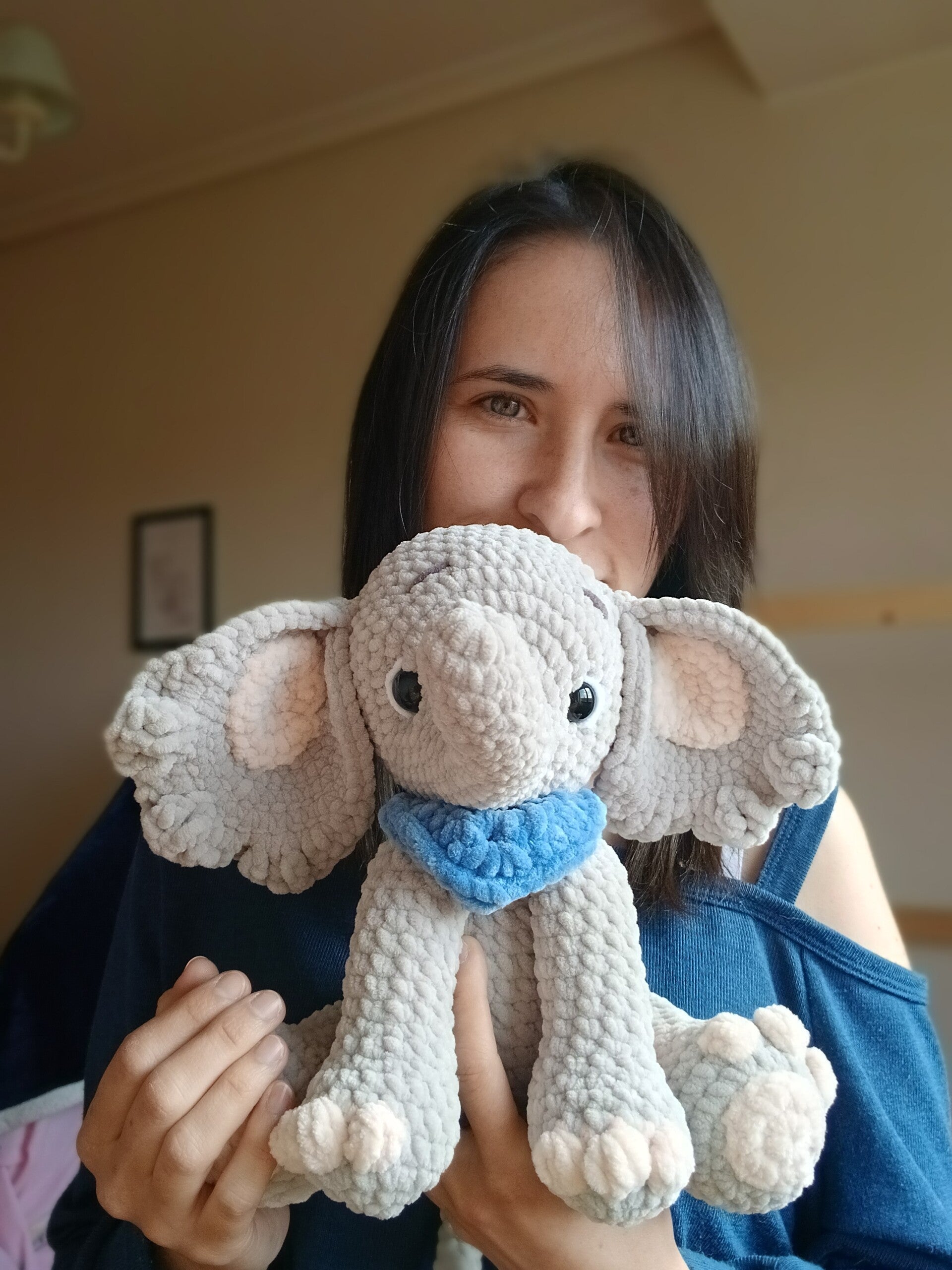 Dani creadora de Tejiendo Latidos, junto a un elefante amigurumi tejido a mano