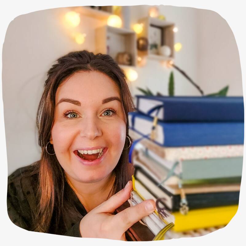 Reneé Sloot met een stapel bullet journals.