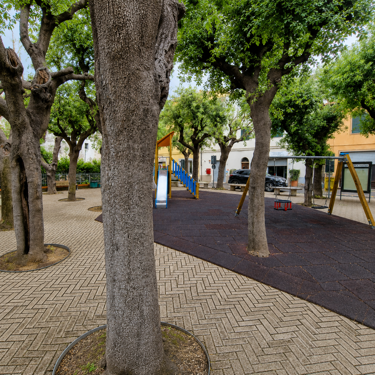 Parco di Lajatico with its playground and the bust of Andrea Bocelli beneath the shade of mature trees.