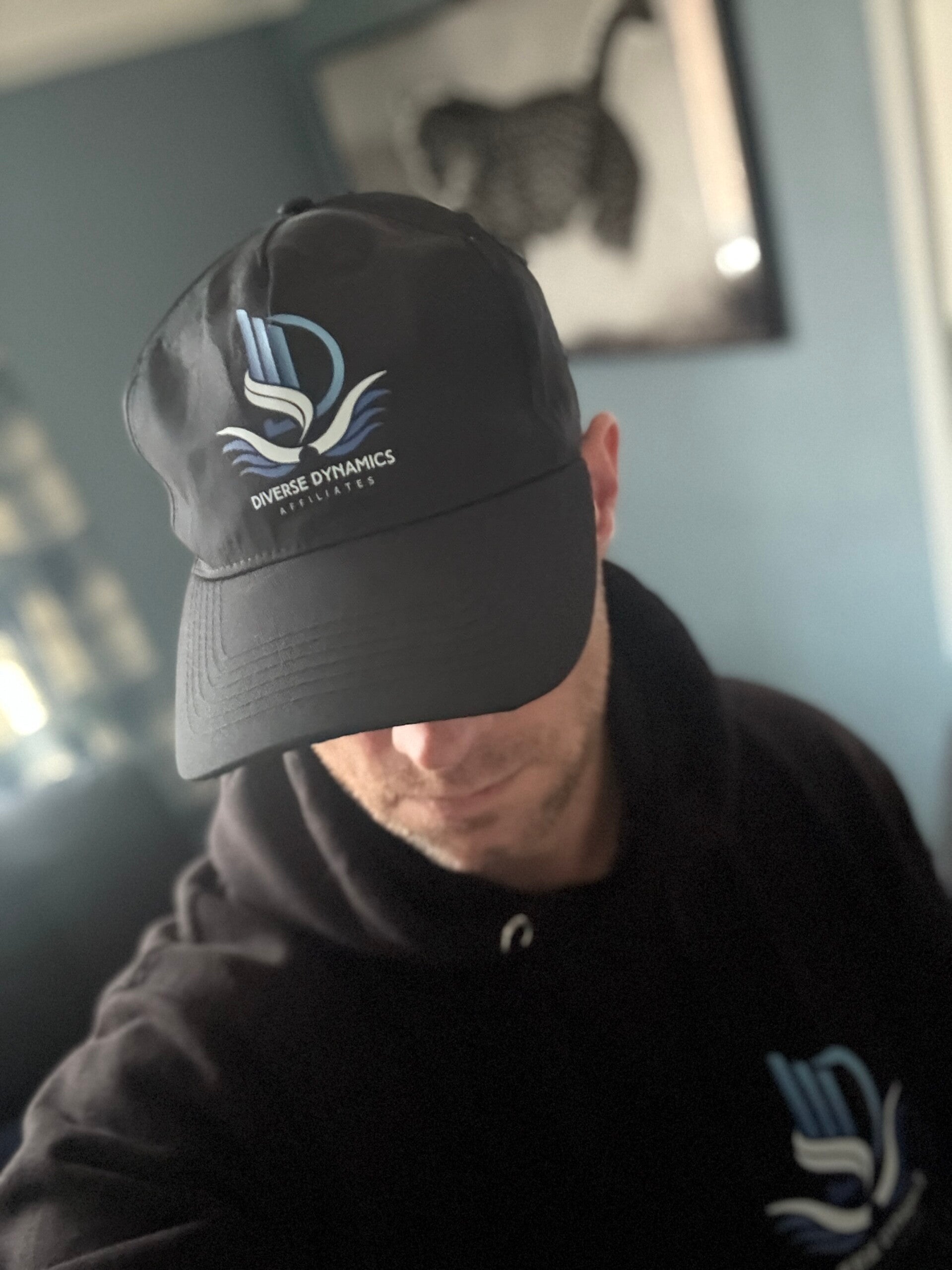 Owner of Diverse dynamics affiliates wearing a  branded cap and hoodie 