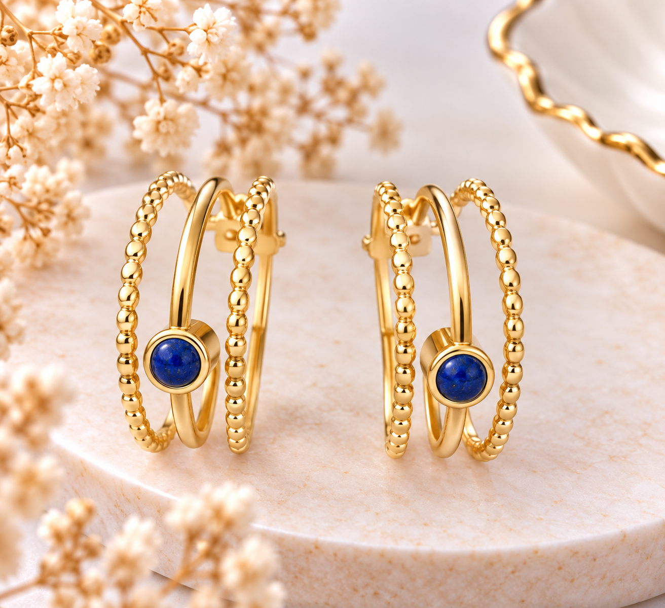 Boucles d’oreilles créoles dorées à triple anneau et pierre bleue