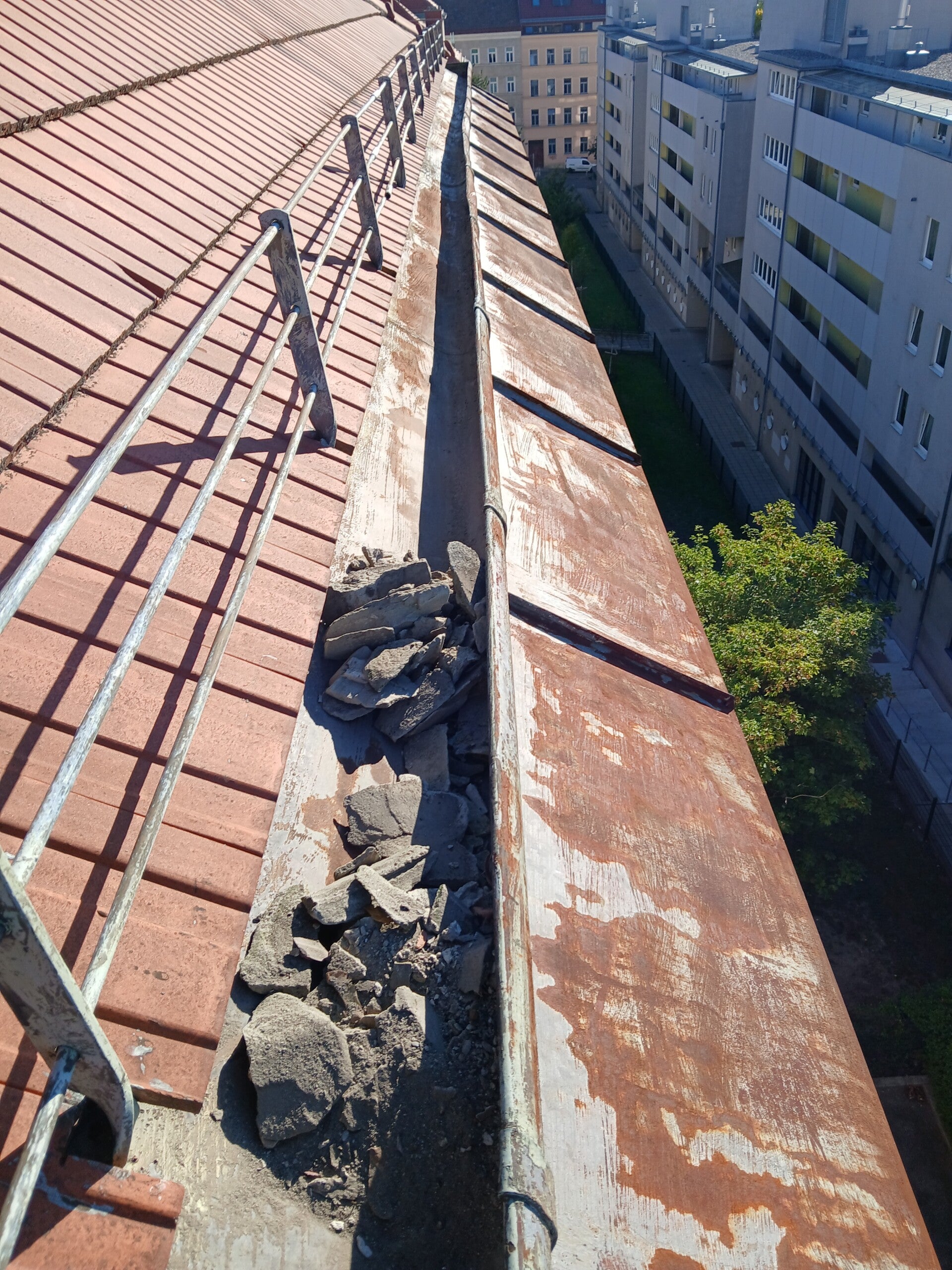 Dachrinne mit Bauschutt vor der Reinigung