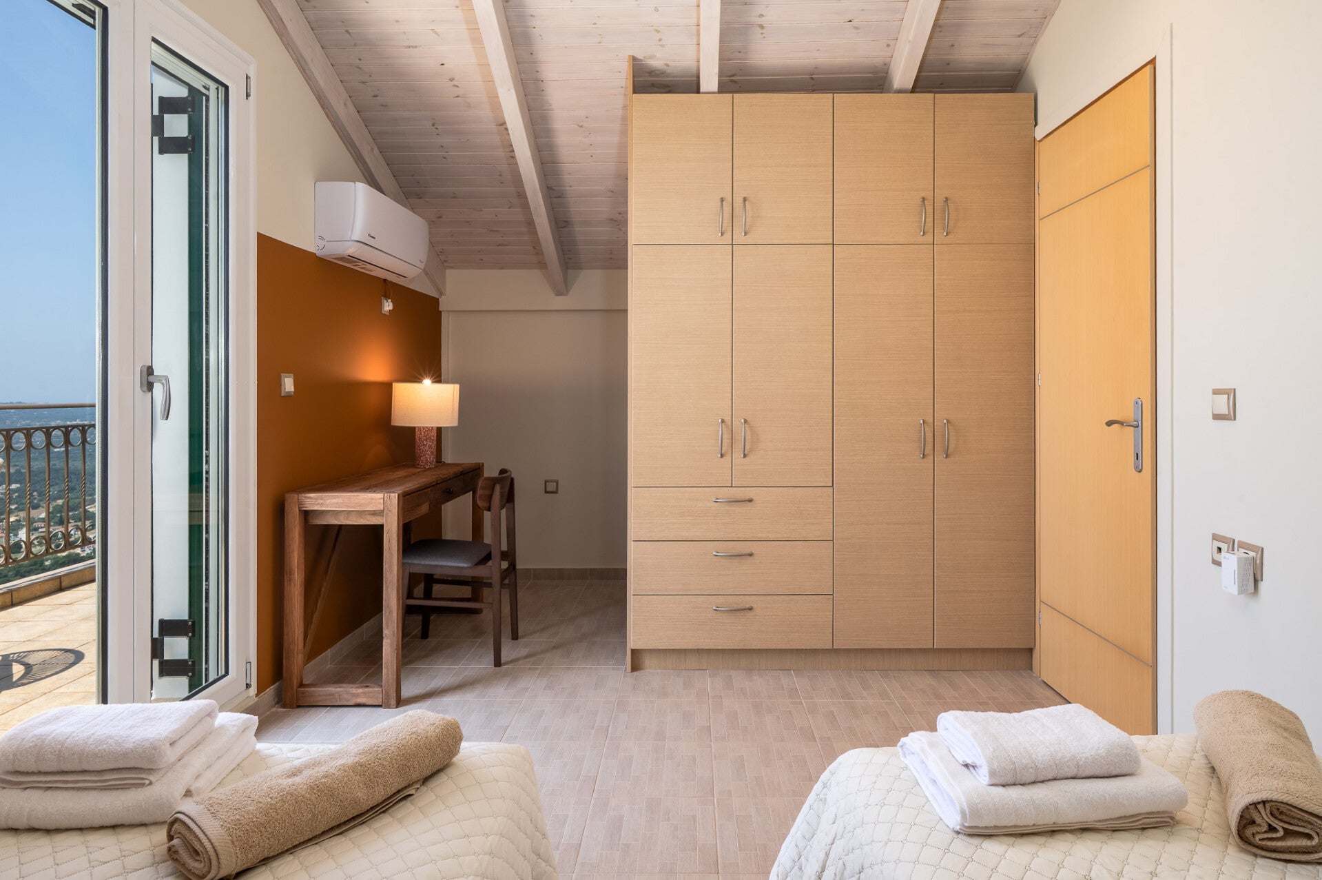 Twin bedroom storage and balcony access at Trithea Villa