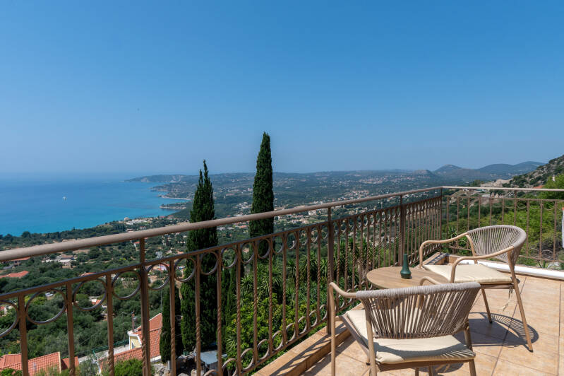 Coastal view from villa balcony with cypress trees and the Ionian Sea in Vlachata, Kefalonia, Greece.