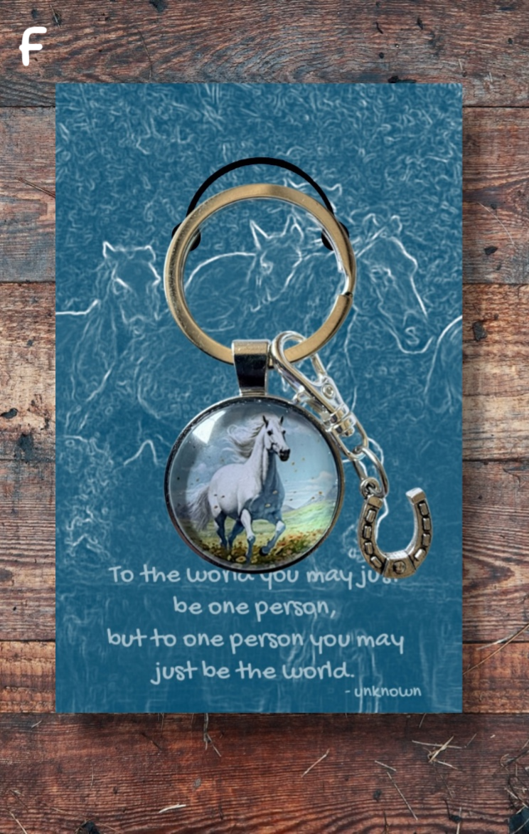 White horse running, with silver horseshoe charm on blue card