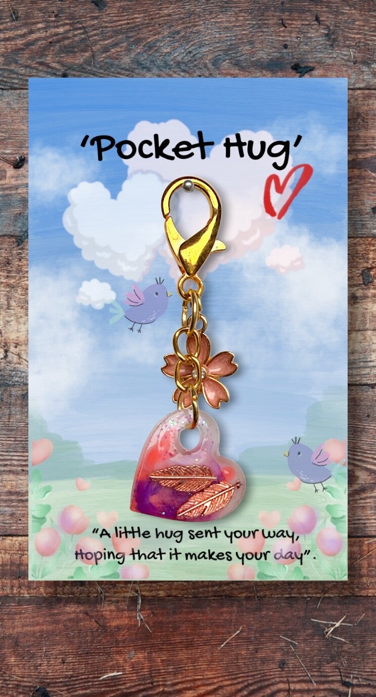 Cute little golden feathers embedded in a heart, with a flower charm
