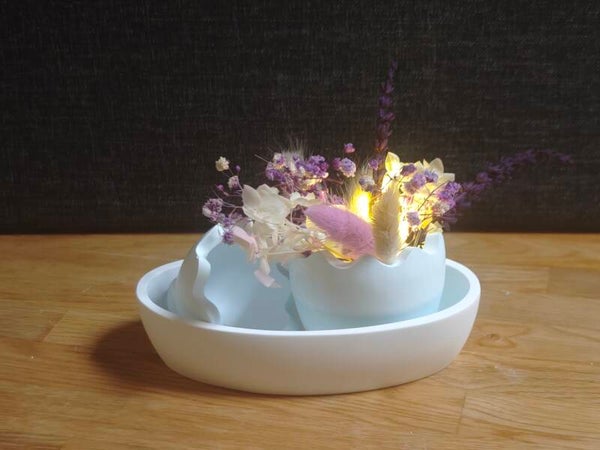 Schale mit Osterei und Dekoblumen