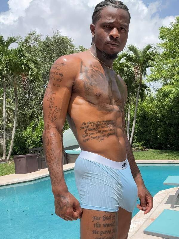 Young Black pornstar Damian Dayski with braids, modeling tight underwear with huge dick bulge by the pool. Showing dominance and authority in the porn industry.