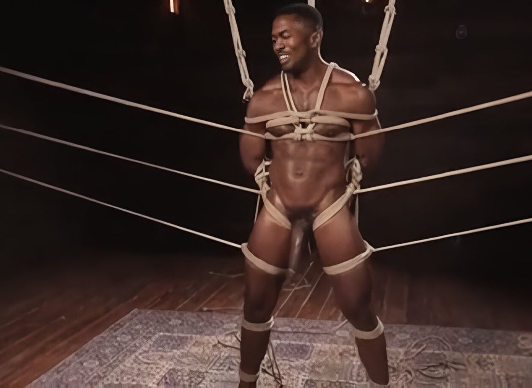 Muscular African American man smiling, bound in intricate rope harness inside a boxing ring, symbolizing dominance, alpha masculinity, and rope bondage artistry.