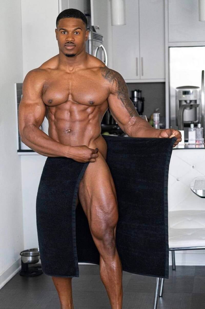 Handsome black man with impressive muscles and a black towel, showcasing body worship rituals and confidence building