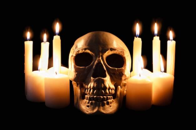 Human skull illuminated by candlelight, eight glowing candles against dark backdrop, gothic theme or alter for sub In bdsm